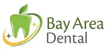 The image shows a logo with the text BAY AREA DENTAL prominently displayed above a graphic representation of a dental tooth, which is stylized with a green apple on top. Below the tooth, there s a circular emblem featuring a toothbrush and dental floss. The background is gray, and the overall style appears to be a digital graphic or logo design.